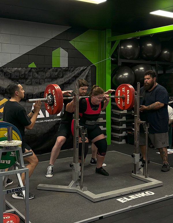 lady about to squat in a powerlifting competition